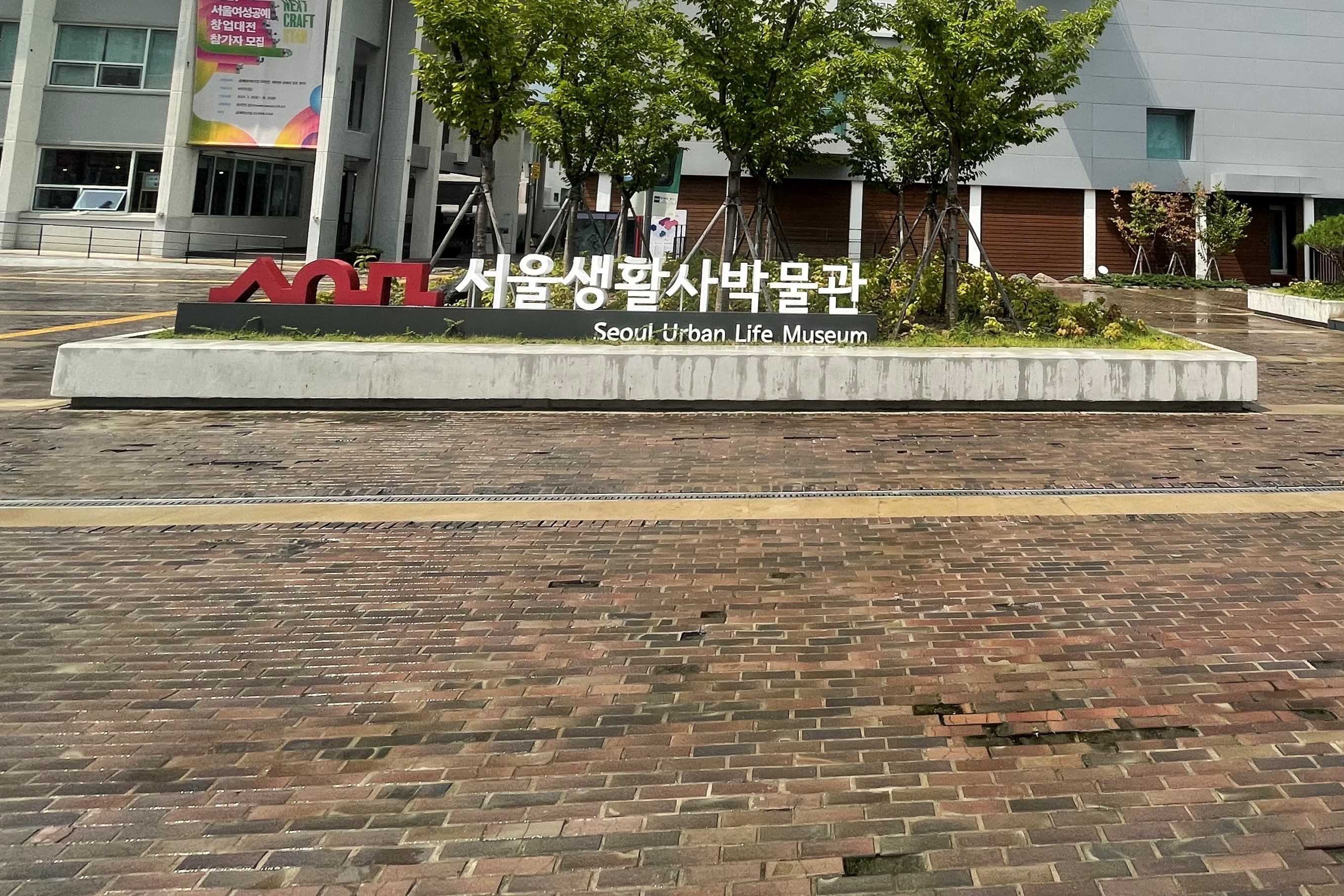 Entryway/ Main entrance 0 : The signboard of museum installed on the red brick road

